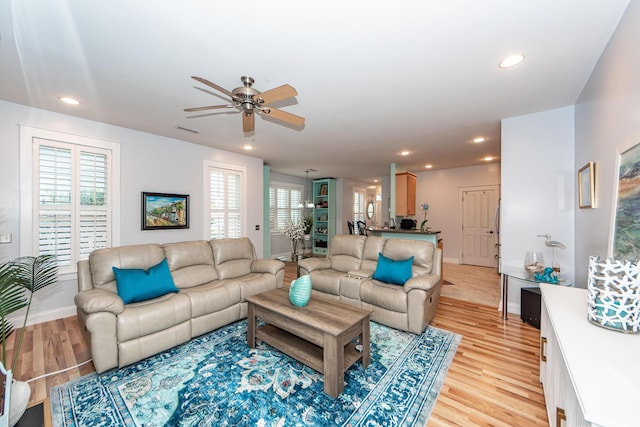 living room with light hardwood / wood-style floors and ceiling fan