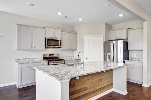 104 Wild Orchid Way, Huger, SC 29450 - kitchen featuring stainless steel appliances, dark wood finished floors, an island with sink, light stone counters, and recessed lighting