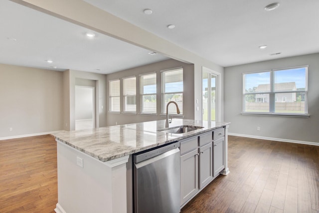 104 Wild Orchid Way, Huger, SC 29450 - kitchen with stainless steel dishwasher, wood-type flooring, light stone counters, an island with sink, and open floor plan