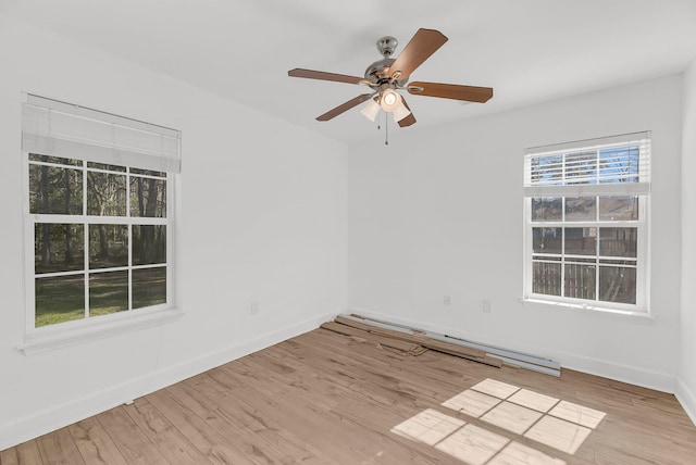 empty room with wood finished floors, a ceiling fan, and baseboards