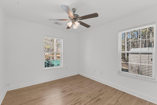 empty room featuring ceiling fan, light wood-type flooring, visible vents, and baseboards