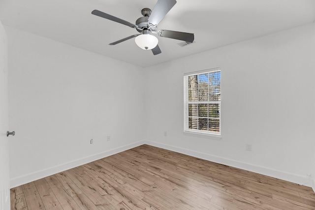 spare room with light wood finished floors, baseboards, and a ceiling fan