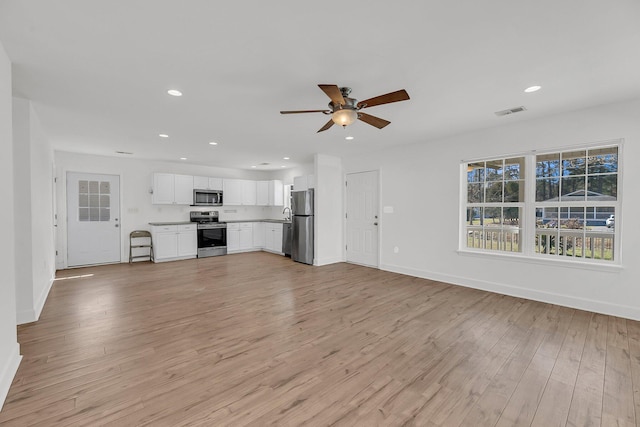 unfurnished living room featuring light wood finished floors, baseboards, visible vents, and recessed lighting