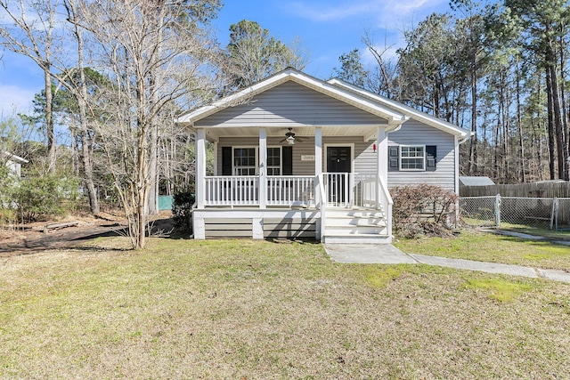 bungalow-style home with ceiling fan, a porch, a front lawn, and fence