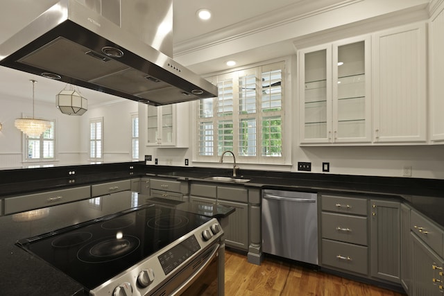 2258 Arthur Gaillard Ln, Charleston, SC 29414 - kitchen featuring appliances with stainless steel finishes, exhaust hood, crown molding, gray cabinets, and dark countertops