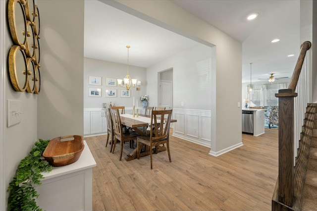 127 Surfbird Rd, Summerville, SC 29486 - dining room with light wood-style flooring, ceiling fan with notable chandelier, stairs, wainscoting, and recessed lighting