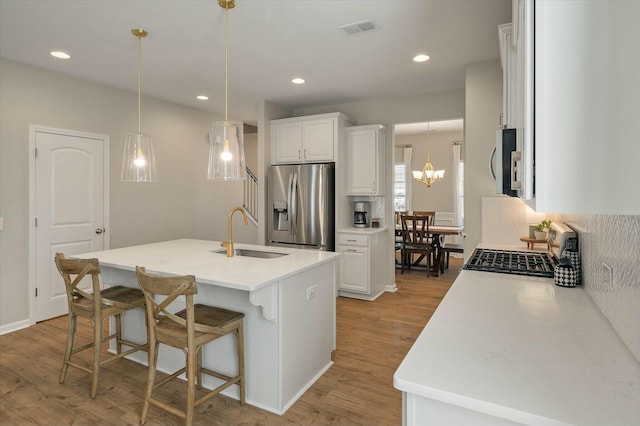 127 Surfbird Rd, Summerville, SC 29486 - kitchen featuring light wood finished floors, a kitchen bar, a sink, visible vents, and appliances with stainless steel finishes