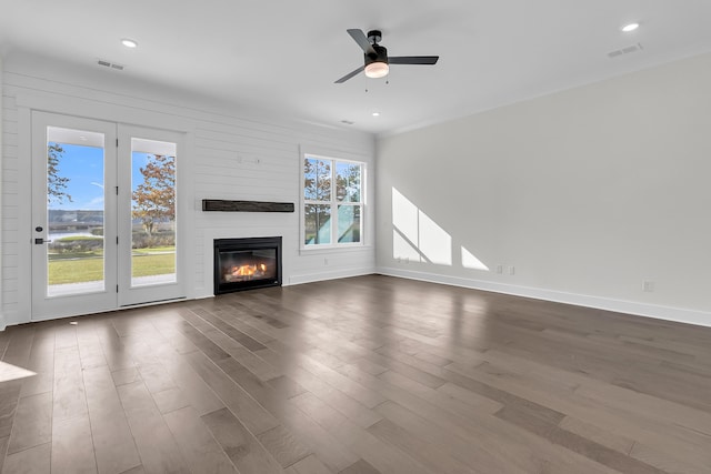 unfurnished living room with wood-type flooring, ceiling fan, and a fireplace