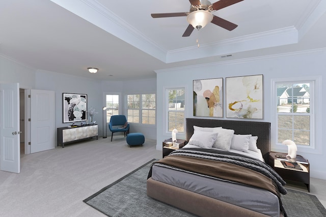 carpeted bedroom featuring multiple windows, crown molding, ceiling fan, and a tray ceiling