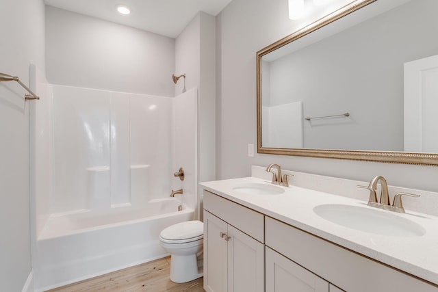 full bathroom featuring hardwood / wood-style flooring, shower / washtub combination, vanity, and toilet