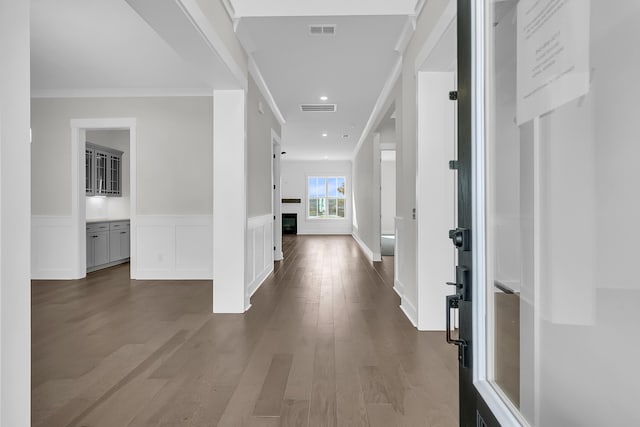 hallway featuring ornamental molding and dark hardwood / wood-style flooring