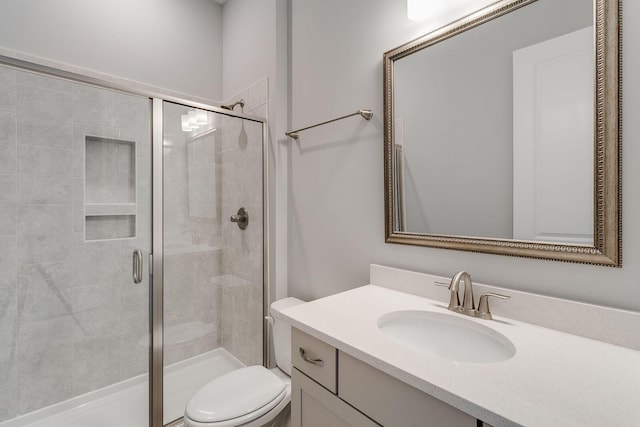 bathroom with an enclosed shower, vanity, and toilet