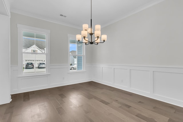 unfurnished dining area with crown molding, dark hardwood / wood-style floors, and a chandelier