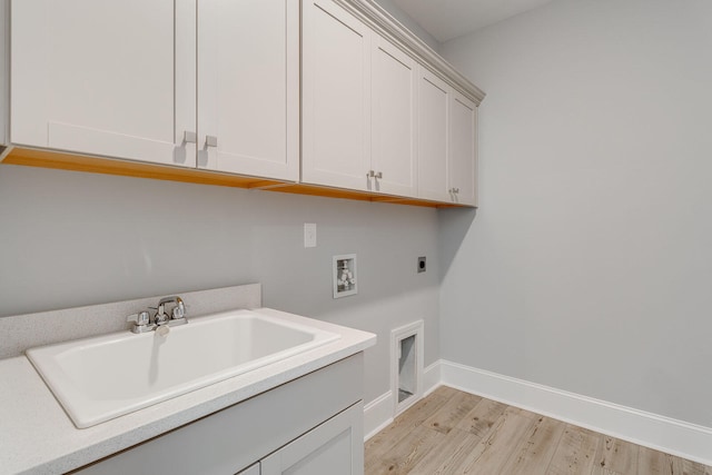 clothes washing area featuring sink, light hardwood / wood-style flooring, electric dryer hookup, hookup for a washing machine, and cabinets