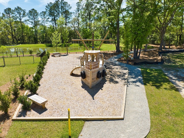 view of home's community with a playground, a water view, and a lawn