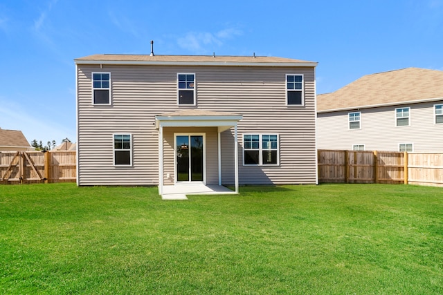 rear view of house with a yard and a patio