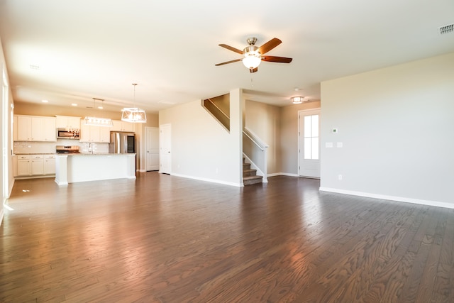 unfurnished living room with ceiling fan, sink, and dark hardwood / wood-style flooring