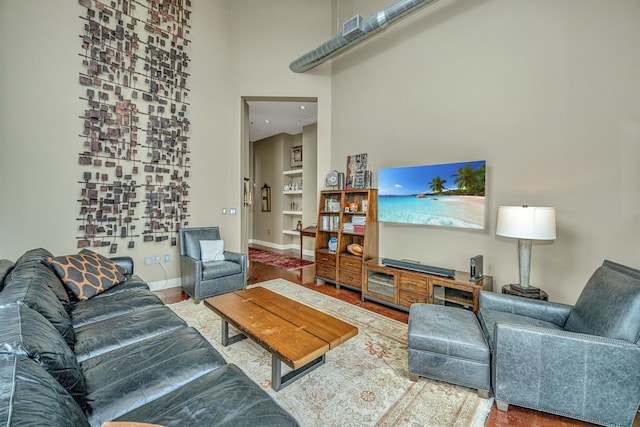 living room featuring a towering ceiling and baseboards