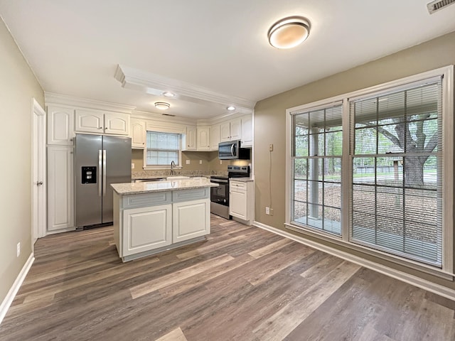 kitchen with baseboards, white cabinetry, wood finished floors, and stainless steel appliances