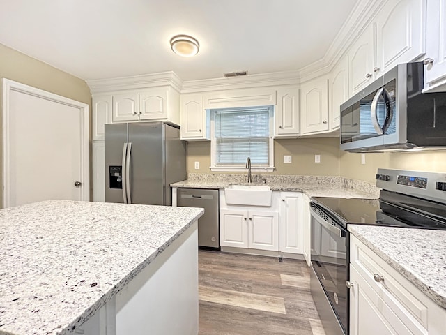 kitchen featuring a sink, white cabinets, light wood-style flooring, and stainless steel appliances