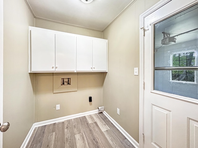 clothes washing area with ornamental molding, light wood finished floors, hookup for a washing machine, and cabinet space