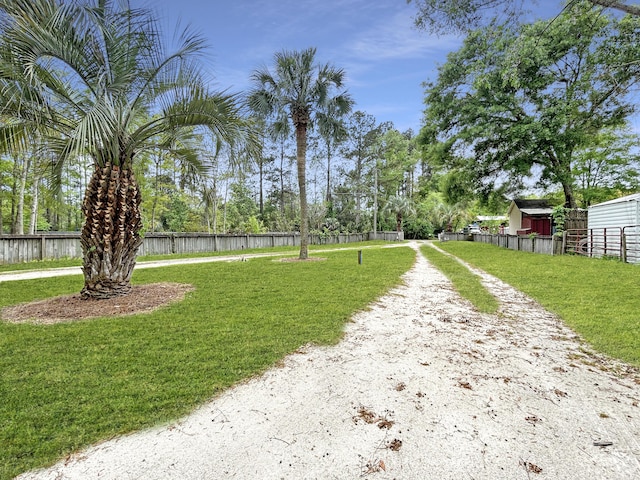 view of property's community featuring a yard and fence