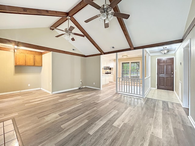 unfurnished living room with vaulted ceiling with beams, ceiling fan, light wood finished floors, and baseboards