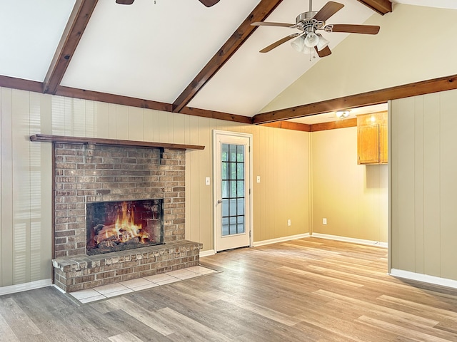 unfurnished living room featuring baseboards, a fireplace, a ceiling fan, light wood-style floors, and beam ceiling
