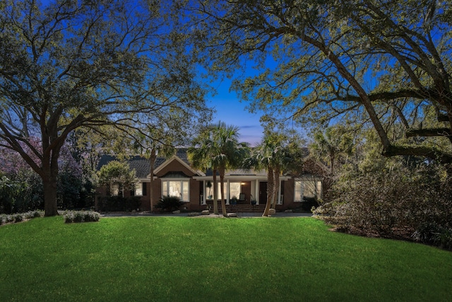 single story home with brick siding and a lawn