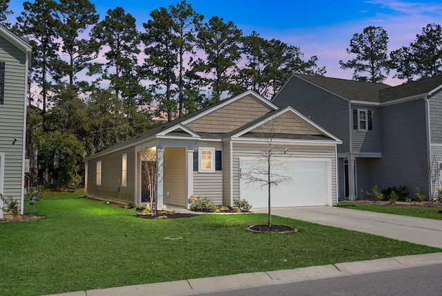 view of front of home with a yard, a garage, and driveway