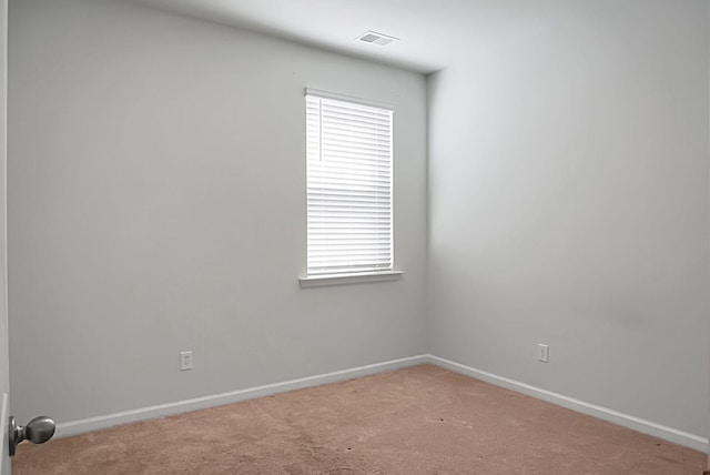 unfurnished room featuring a healthy amount of sunlight, baseboards, and light carpet