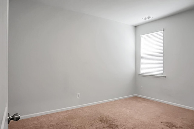 carpeted empty room with visible vents and baseboards