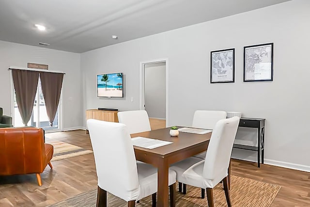 dining room with visible vents, baseboards, and wood finished floors