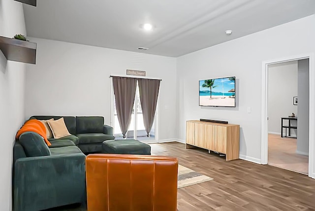 living room featuring visible vents, baseboards, and wood finished floors