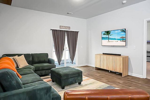 living area with visible vents, baseboards, and dark wood-style flooring