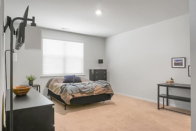 bedroom featuring visible vents, light colored carpet, and baseboards