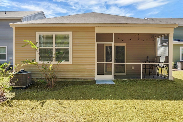 rear view of property with a patio area, a lawn, central AC, and a sunroom