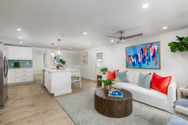 living room featuring recessed lighting, light wood finished floors, ceiling fan, and baseboards