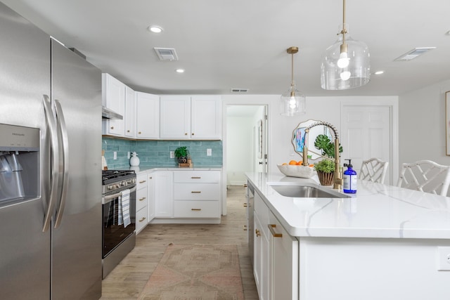 kitchen featuring a kitchen island with sink, light wood-style floors, appliances with stainless steel finishes, a sink, and visible vents