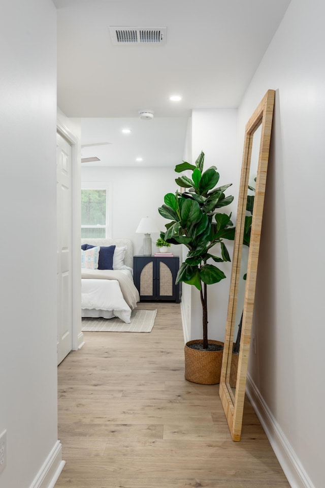 corridor featuring recessed lighting, visible vents, light wood-style flooring, and baseboards
