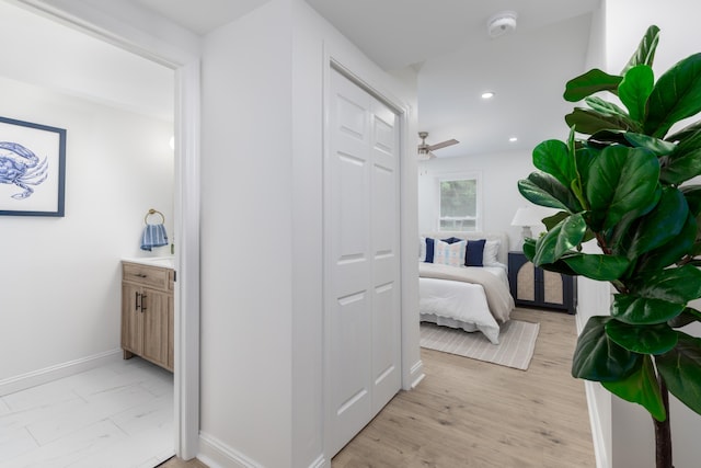 hallway with light wood-type flooring, recessed lighting, and baseboards