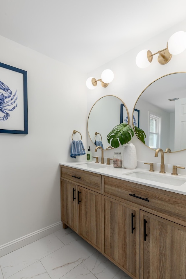 bathroom with marble finish floor, a sink, and double vanity