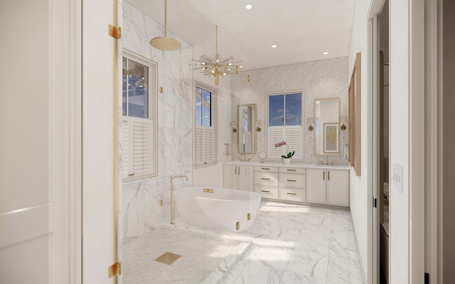 full bathroom featuring vanity, a shower, marble finish floor, a freestanding bath, and a notable chandelier