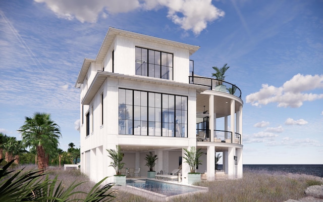 back of house featuring a patio area, a ceiling fan, stucco siding, and a balcony