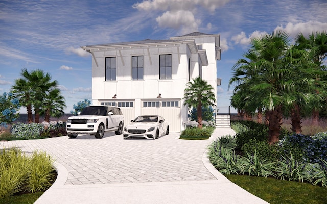 view of front of home featuring an attached garage, decorative driveway, and stucco siding