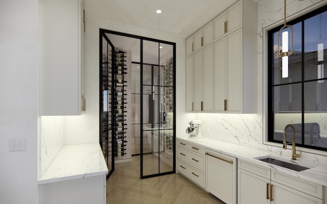 kitchen featuring dishwasher, white cabinetry, a sink, and backsplash