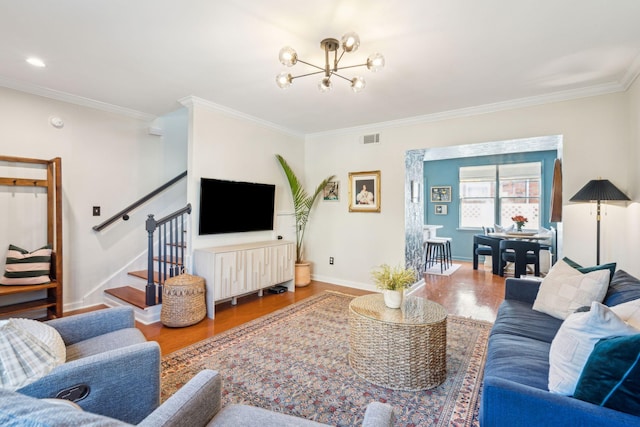 living room featuring hardwood / wood-style floors, ornamental molding, and a notable chandelier