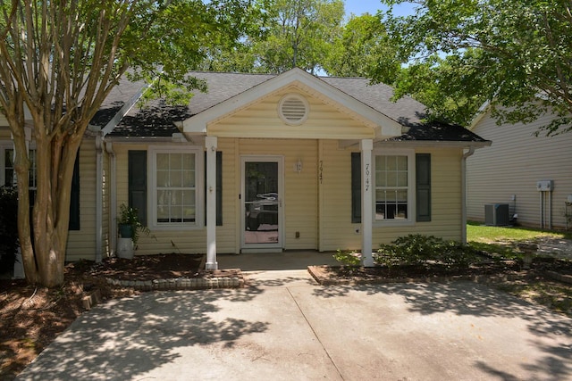 7947 Vermont Rd, North Charleston, SC 29418 - view of front of home featuring a shingled roof, cooling unit, and a patio area