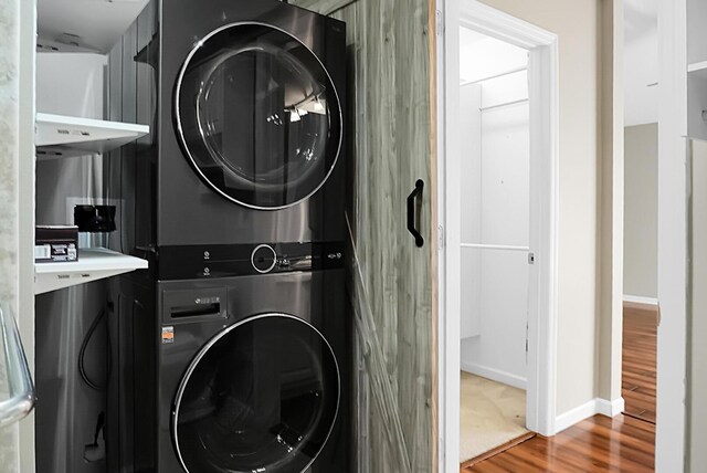 7947 Vermont Rd, North Charleston, SC 29418 - laundry area featuring stacked washing machine and dryer, wood finished floors, and baseboards