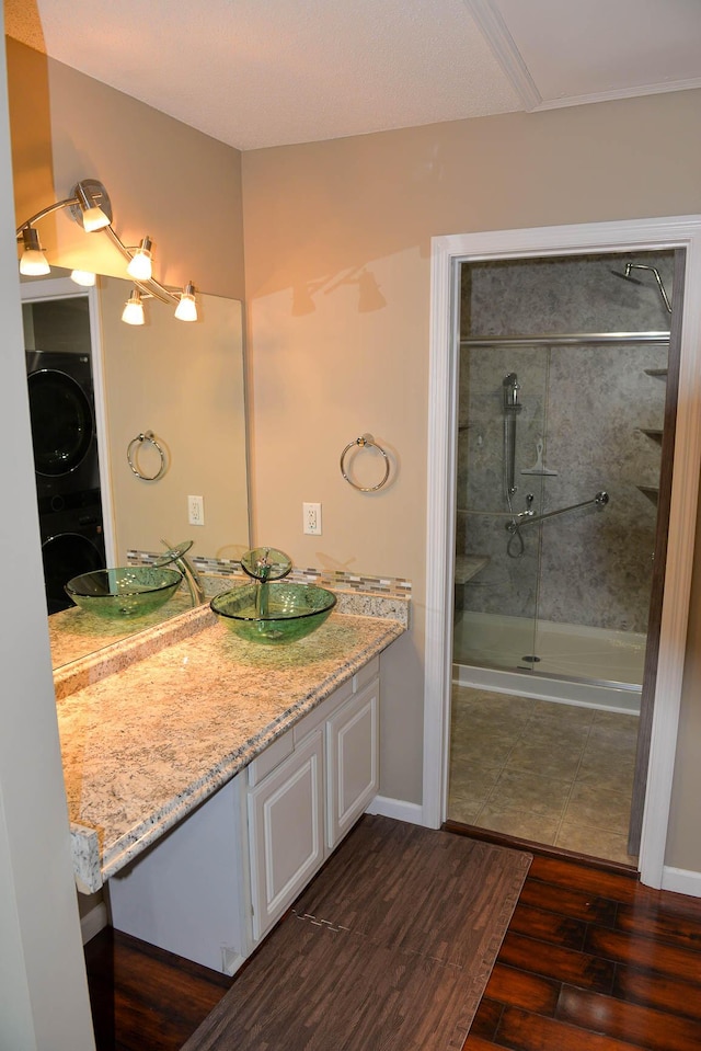 7947 Vermont Rd, North Charleston, SC 29418 - full bath with estacked washer and dryer, wood finished floors, vanity, a shower with door, and baseboards